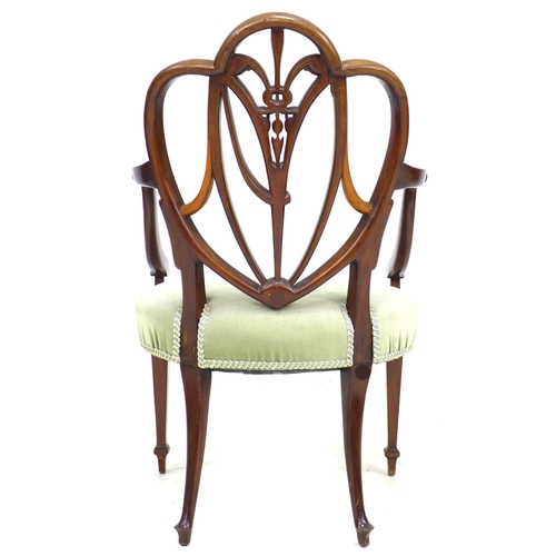 325 - An early 19th century mahogany open arm chair, after a Hepplewhite design, with open trefoil heart s... 