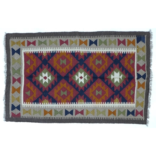 326 - A Maimana Kilim rug with red ground, three white and olive green lozenges, white and grey dentil key... 