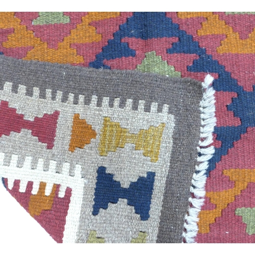 326 - A Maimana Kilim rug with red ground, three white and olive green lozenges, white and grey dentil key... 