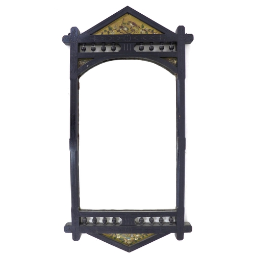 338 - An Arts & Crafts ebonised mahogany wall mirror, with decorative carved frame, triangular panels to t... 