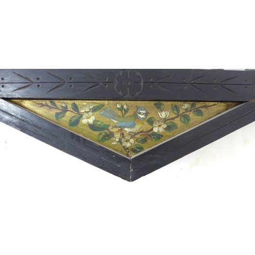 338 - An Arts & Crafts ebonised mahogany wall mirror, with decorative carved frame, triangular panels to t... 