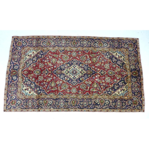 349 - A Kashan rug with red ground, central dark blue and cream floral medallion with pendant anchors, flo... 