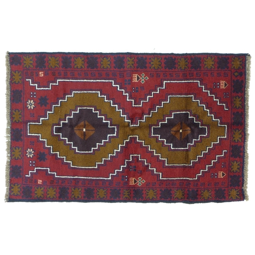 351 - A Baluchi rug with red ground, two medallions in shade varying shades of brown with thin white and d... 