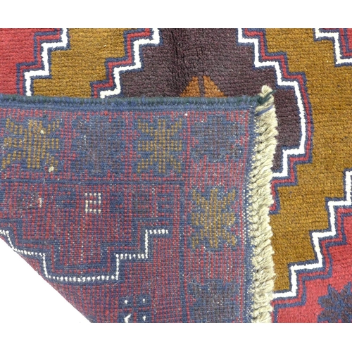 351 - A Baluchi rug with red ground, two medallions in shade varying shades of brown with thin white and d... 