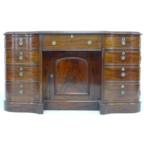 354 - A Victorian mahogany knee hole desk, of serpentine, breakfront outline, with six drawers and two cup... 