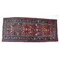 A Hamadan runner with red ground, stylised floral field, two light blue and one dark blue floral bor... 