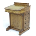 A late Victorian walnut Davenport, with marquetry inlaid top, a leather inset to its writing slope, ... 