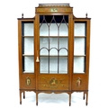 An Edwardian Sheraton style satinwood veneered breakfront display cabinet, the whole with painted de... 
