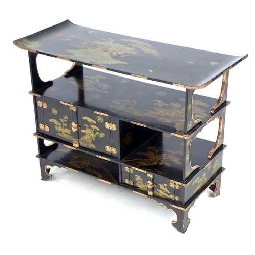 369 - A low Japanese black lacquer shelf unit, Meiji period, with engraved copper mountings, decorated in ... 