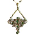 An emerald set pendant of delicate scrolling design, in Art Nouveau style, possibly Indian, yellow a... 