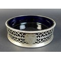 A George III silver wine coaster, with bead rim, pierced floral decorated sides with an armorial mar... 