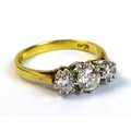 An 18ct gold and diamond three stone ring, the central round cut stone of approximately 0.25ct, tota... 