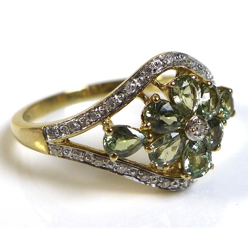 282 - A 9ct gold, diamond and green stone ring, likely green amethyst, with central diamond to a flower se... 