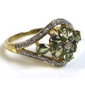 A 9ct gold, diamond and green stone ring, likely green amethyst, with central diamond to a flower se... 