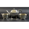 An Art Deco silver tea set, of curvilinear design with incuse corners, raised on four ball feet, Fra... 