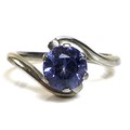 An 18ct white gold and solitaire tanzanite in a swirl setting, tanzanite approximately 6.9mm diamete... 