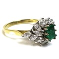A 18ct gold, diamond and emerald ring, the central emerald cut emerald, 6 by 4.4mm, surrounded by fo... 