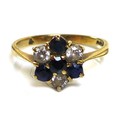A 9ct gold, diamond and sapphire flowerhead ring, central round cut sapphire set about with three fu... 