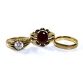 A group of three 9ct gold rings, comprising a gentlemen's ring set with an oval red stone, possibly ... 