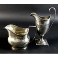 Two pieces of George III silver, comprising a helmet form milk jug, with bright cut decoration, bear... 