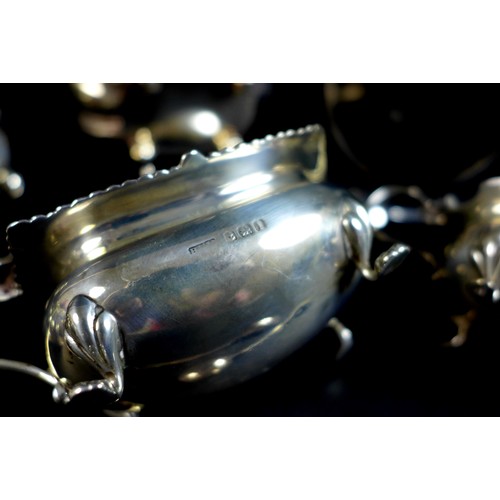 89 - An Edwardian silver cruet set of gadroon bellied cauldron form, with fluted rims and silver gilt int... 