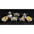 An Edwardian silver cruet set of gadroon bellied cauldron form, with fluted rims and silver gilt int... 