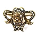 An unmarked yellow gold brooch, in Art Nouveau style with a central theatrical / operatic mask set w... 