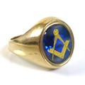 A 9ct gold Masonic gentleman's ring, the blue stone oval carved and inset with gold Freemasons logo,... 