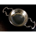 A George V silver lemon strainer, with twin handles, fine bead rim and pierced bowl, Goldsmiths & Si... 
