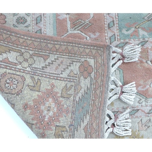 305 - A modern Persian rug with cream ground, pale blue and pink floral decoration, end tassels tied in bu... 