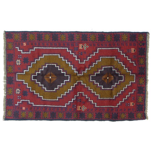 290 - A Baluchi rug with red ground, two medallions in shade varying shades of brown with thin white and d... 