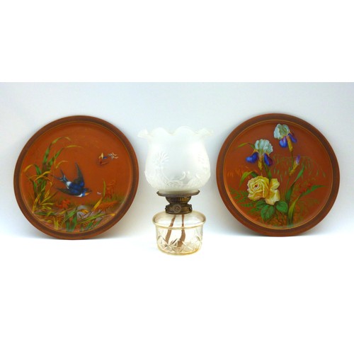49 - A pair of Watcombe Torquay terracotta chargers, one decorated with a swallow flying amongst reeds an... 