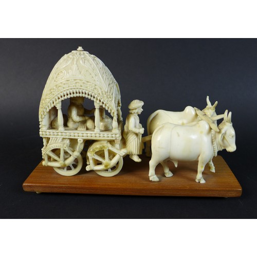 11 - Two 19th century Indian ivory carvings, one of a howdah with two occupants being pulled by a pair of... 