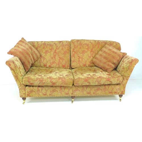 291 - A modern three piece suite, red and gold foliate upholstery, comprising a three / four seater sofa, ... 