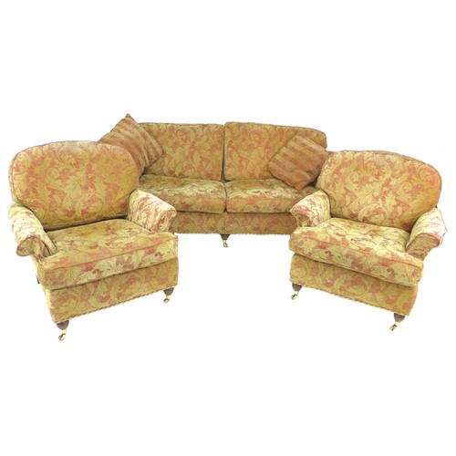 291 - A modern three piece suite, red and gold foliate upholstery, comprising a three / four seater sofa, ... 