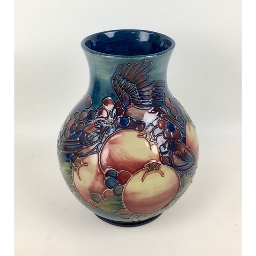 23 - A Moorcroft pottery finch and berry pattern baluster form vase, with impressed marks to base, signed... 