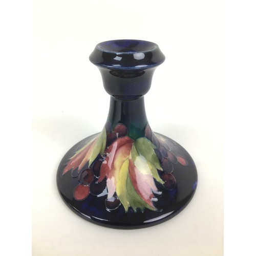 30 - Two mid 20th century and later Moorcroft pottery candlesticks, comprising decorated in the leaf and ... 