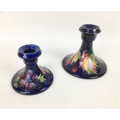 30 - Two mid 20th century and later Moorcroft pottery candlesticks, comprising decorated in the leaf and ... 