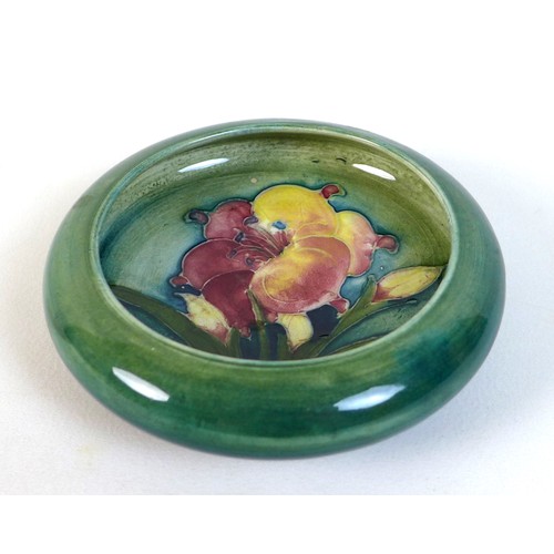 37 - A Moorcroft lipped trinket bowl, tube line and painted, decorated with lillies, impressed Moorcroft ... 