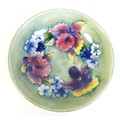 A Moorcroft bowl, the pale green ground decorated with Irises and blue violas, tublined and painted,... 