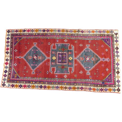 294 - A Hamadan rug with red ground, geometric decoration, 245 by 130cm.