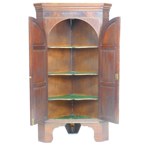 310 - A Victorian mahogany freestanding corner cupboard, twin arched doors opening to reveal three fixed s... 