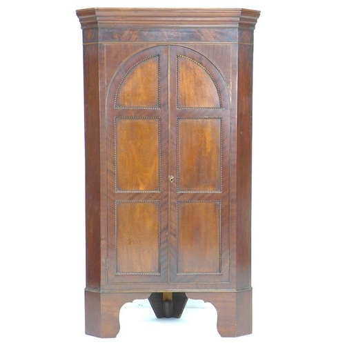 310 - A Victorian mahogany freestanding corner cupboard, twin arched doors opening to reveal three fixed s... 