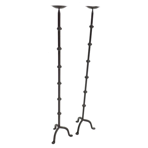 298 - A pair of wrought iron pricket candle stands, each with a circular cupped drip tray on a square sect... 