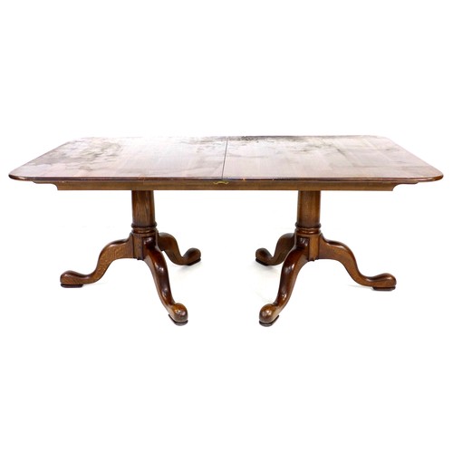 320 - A modern oak twin pedestal dining table, in George II style, the rectangular surface with rounded co... 