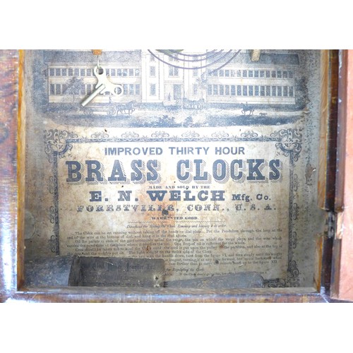 249 - An early 20th century American clock, the enamel dial having Roman numerals and floral spandrels abo... 