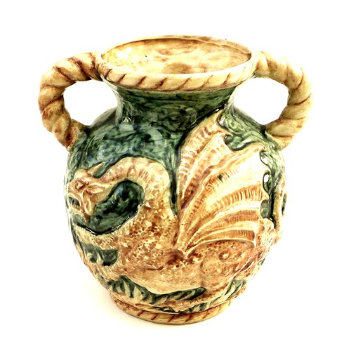 28 - An unusual West German pottery double handled vase, decorated in relief with a dragon on a green gro... 
