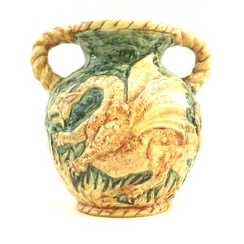 28 - An unusual West German pottery double handled vase, decorated in relief with a dragon on a green gro... 