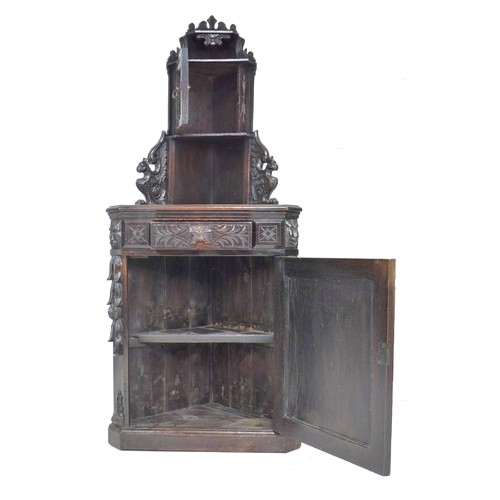 285 - An oak freestanding corner cupboard, mid to early 20th century, carved in Dutch style with lion’s ma... 