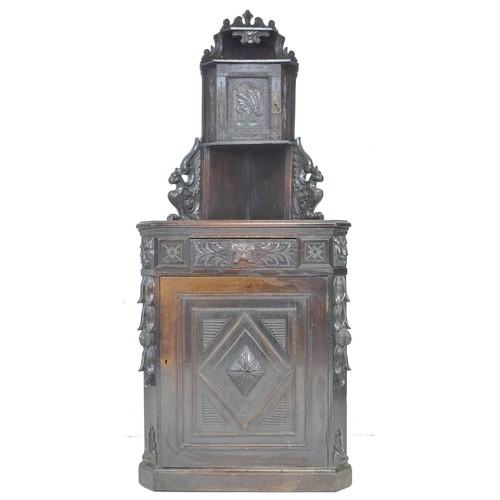 285 - An oak freestanding corner cupboard, mid to early 20th century, carved in Dutch style with lion’s ma... 